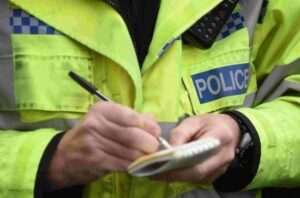 Police officer writing in notebook