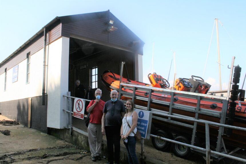 Clive (middle) with friends Morris and Anne Marie Stallard standing in front of the extended lifeboat boathouse