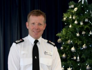 Chief Consable Scott Chilton next to Christmas tree