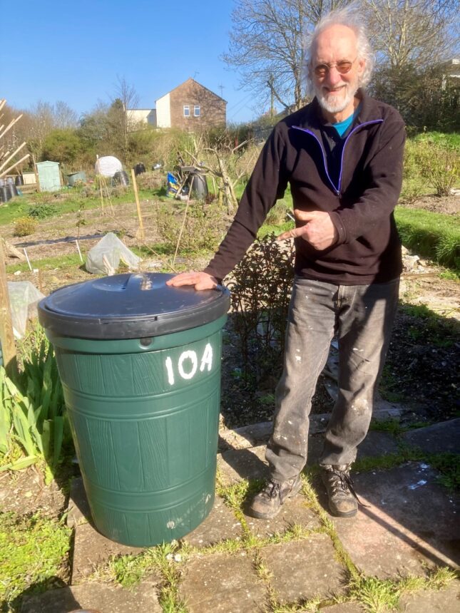 A happy allotment holder recipients with his water butt