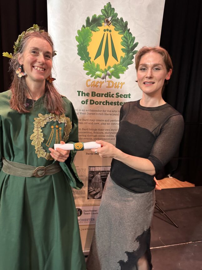 Former bard Rebecca handing over the scroll
